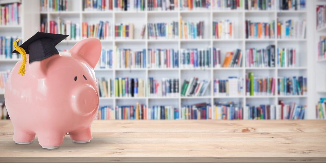 Composite image of piggy bank with graduation hat