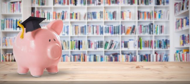 Composite image of piggy bank with graduation hat